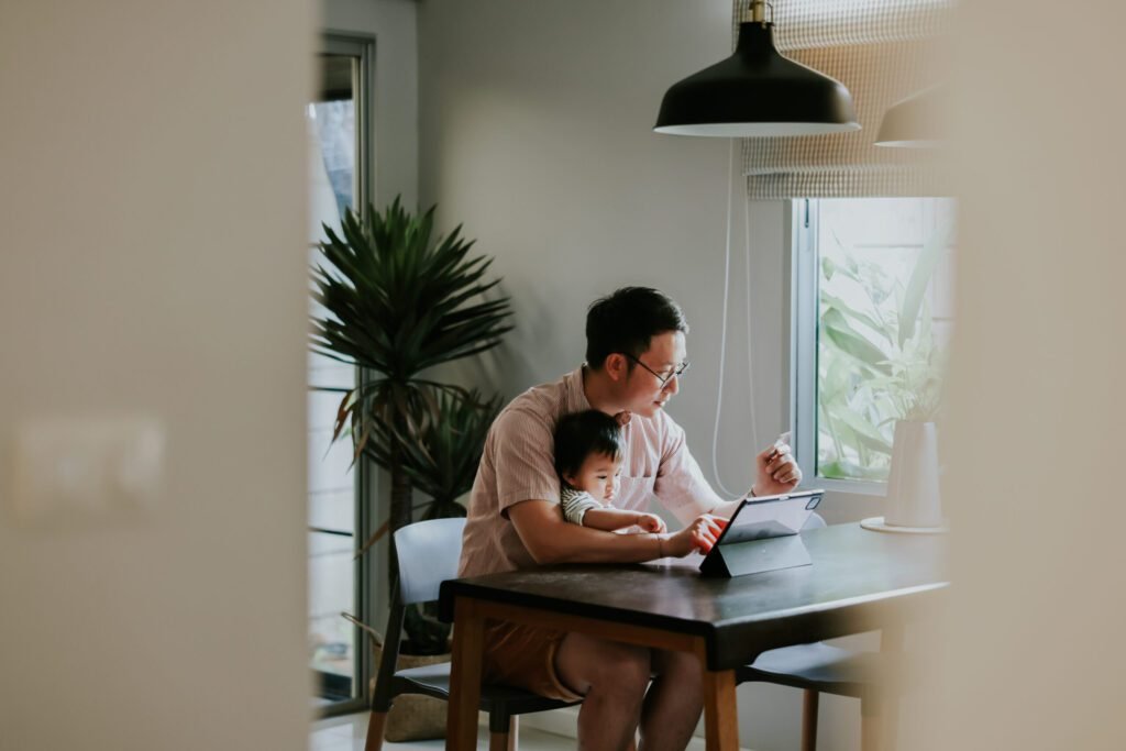 A man and his son sat at the computer