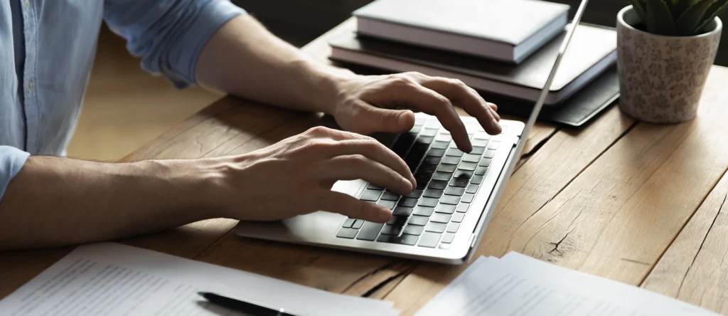 Someone filling in a document on their laptop.
