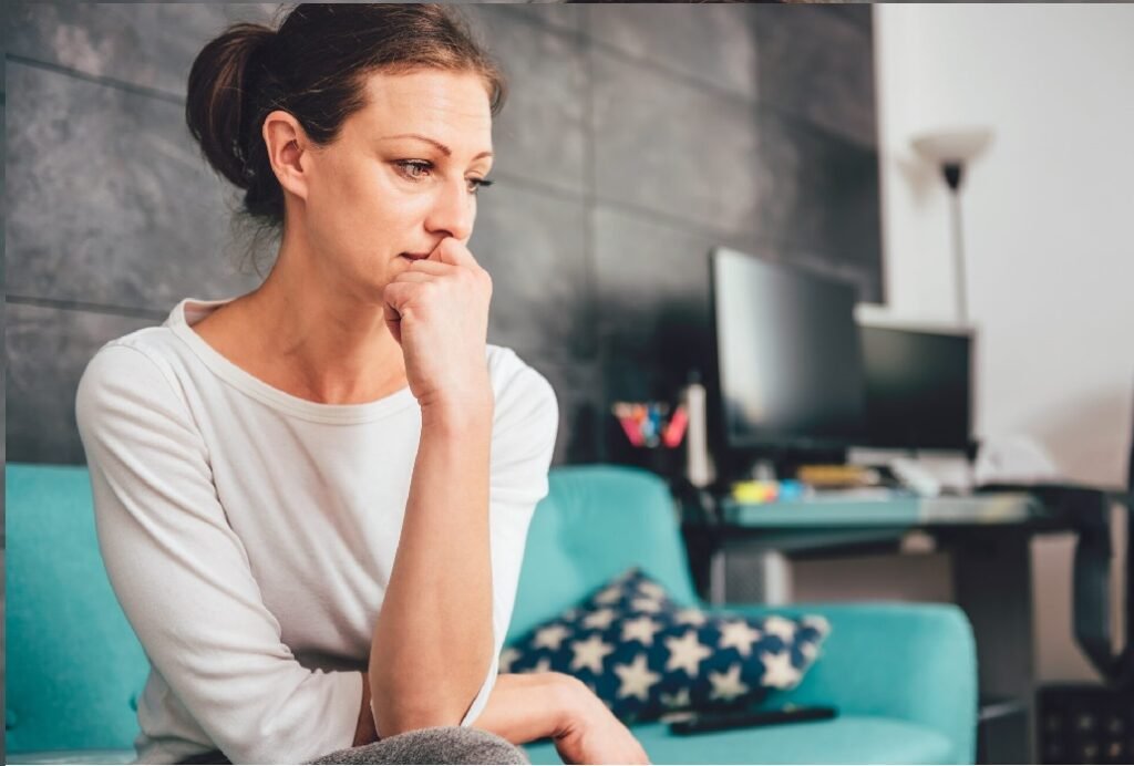 Sad woman sitting on a sofa in the living room
