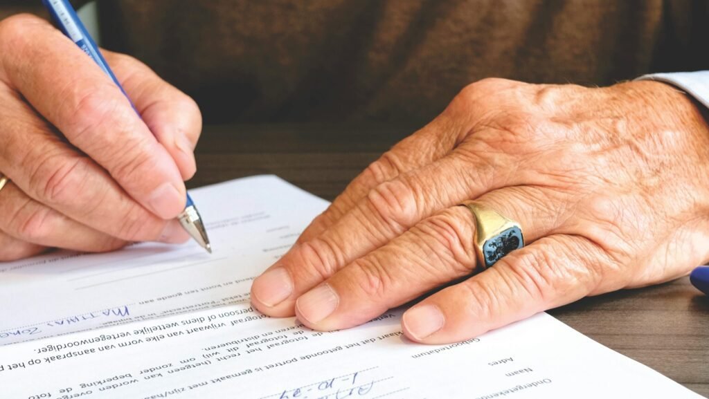 Mans hands signing papers